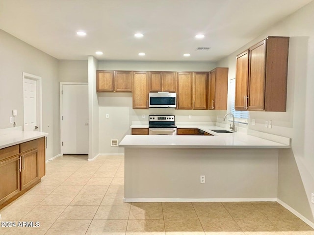 kitchen featuring light tile patterned flooring, kitchen peninsula, stainless steel appliances, and sink