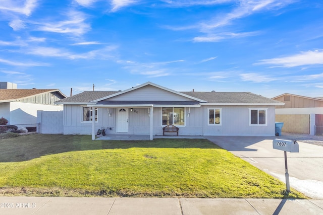 ranch-style home featuring covered porch and a front lawn