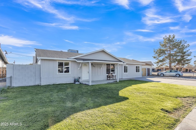 ranch-style house featuring covered porch and a front lawn