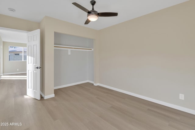 unfurnished bedroom with ceiling fan, light wood-type flooring, and a closet