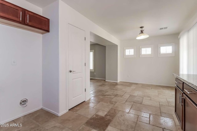 23162 W Lasso Ln, Buckeye, AZ 85326 - unfurnished dining area featuring stone tile flooring and baseboards