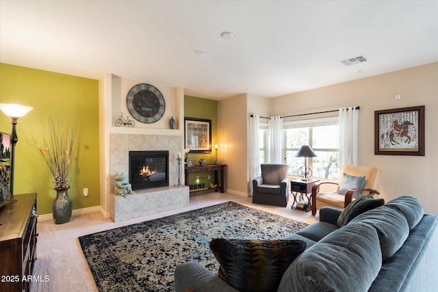 living room with a tile fireplace and light colored carpet