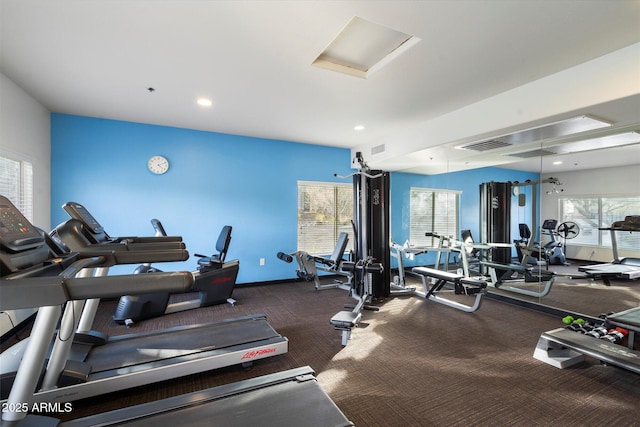 gym with dark colored carpet and a healthy amount of sunlight