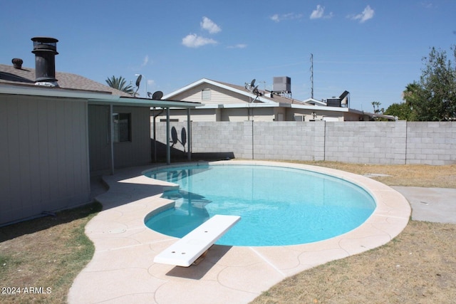 view of pool with a patio area and a diving board