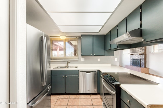 kitchen featuring sink, a fireplace, stainless steel appliances, and light tile patterned flooring