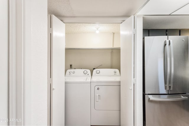 laundry room featuring washing machine and dryer and a textured ceiling