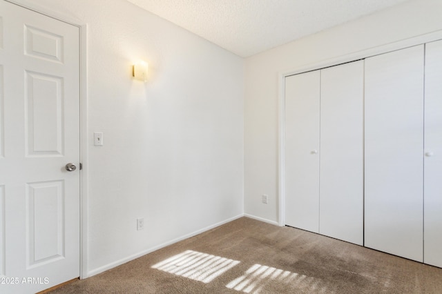 unfurnished bedroom featuring a closet, light carpet, and a textured ceiling