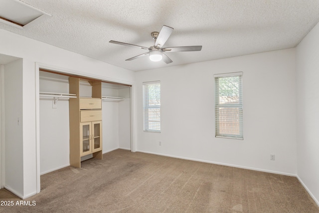 unfurnished bedroom featuring ceiling fan, carpet floors, a textured ceiling, and a closet