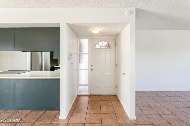 tiled entryway with a textured ceiling