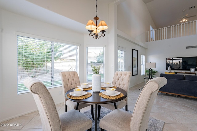 dining space with visible vents, a towering ceiling, light tile patterned floors, baseboards, and a chandelier