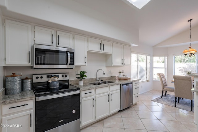 kitchen with lofted ceiling, light tile patterned floors, white cabinets, stainless steel appliances, and a sink