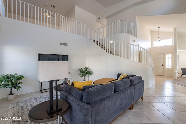 tiled living room featuring stairs, a high ceiling, a notable chandelier, and visible vents