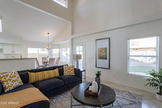 living room featuring light tile patterned floors, baseboards, and a towering ceiling