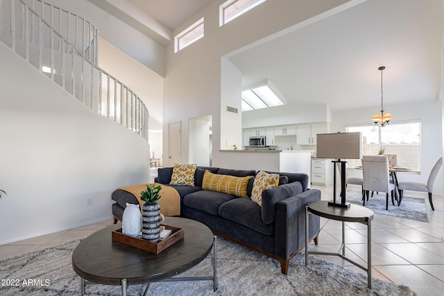 living area with visible vents, baseboards, light tile patterned flooring, and a towering ceiling