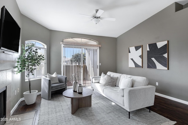 living area featuring vaulted ceiling, wood finished floors, a ceiling fan, and baseboards