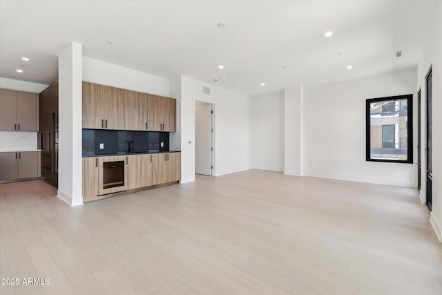 19355 N 73rd Way Unit E-4014, Scottsdale, AZ 85255 - unfurnished living room with wine cooler, light wood-type flooring, recessed lighting, and bar area