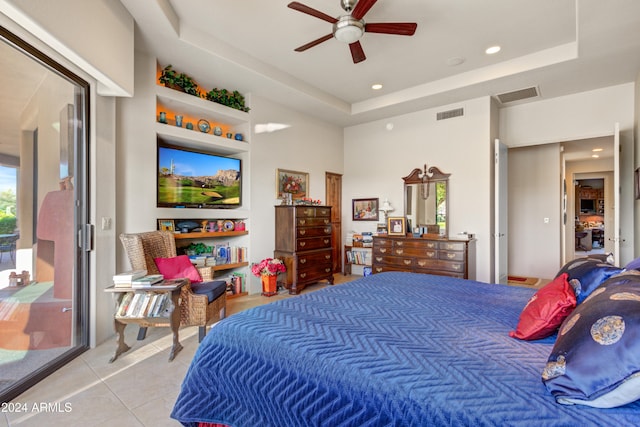 bedroom with a raised ceiling, ceiling fan, and light tile patterned floors