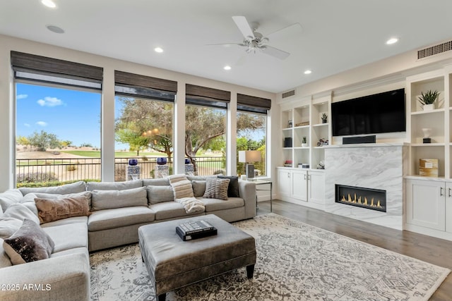 6929 E Montreal Pl, Scottsdale, AZ 85254 - living room featuring visible vents, a ceiling fan, a premium fireplace, and wood finished floors