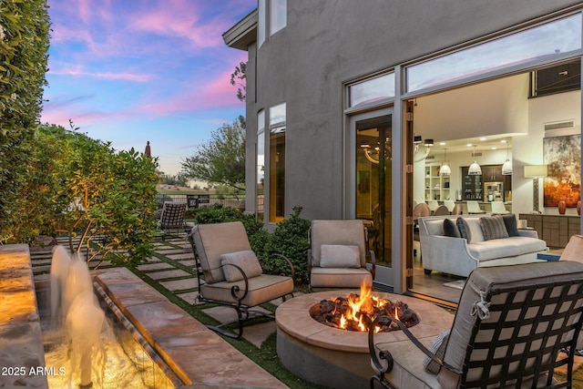6929 E Montreal Pl, Scottsdale, AZ 85254 - patio terrace at dusk featuring fence and an outdoor living space with a fire pit