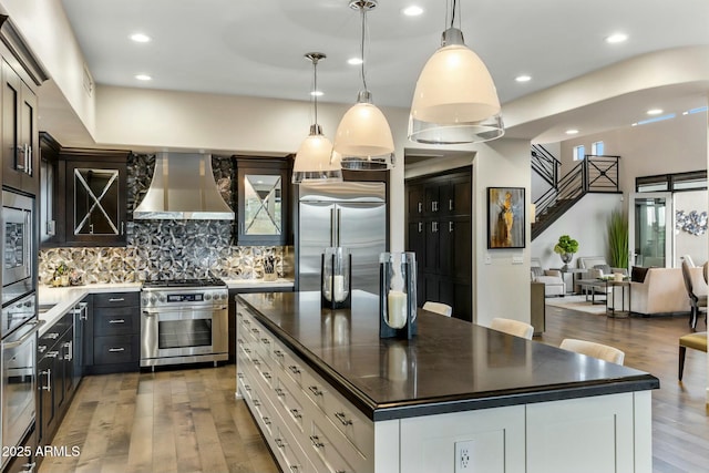 6929 E Montreal Pl, Scottsdale, AZ 85254 - kitchen with ventilation hood, dark countertops, built in appliances, and wood finished floors