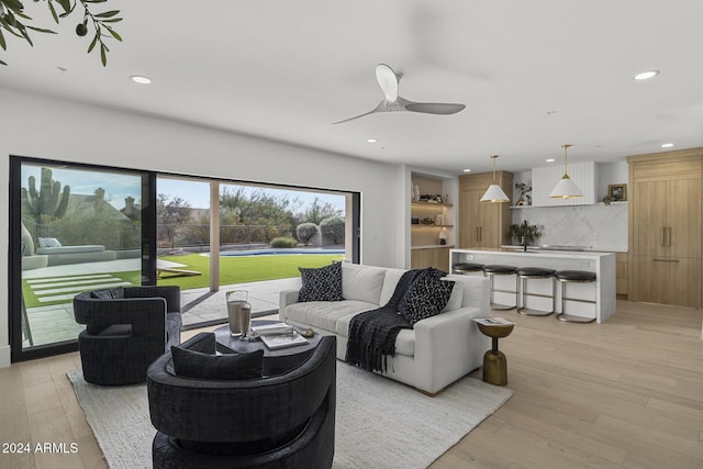 living room with ceiling fan and light hardwood / wood-style floors