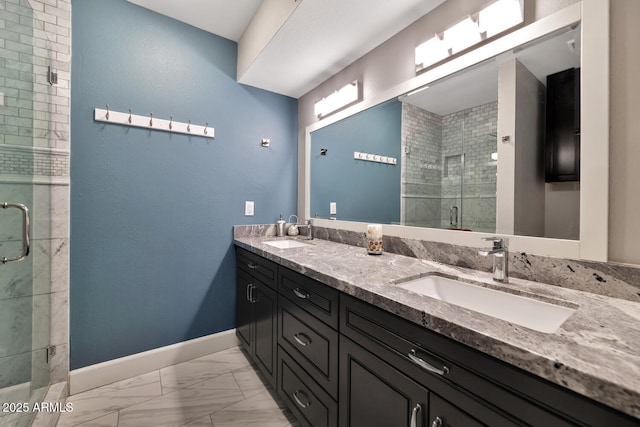 full bathroom with a stall shower, baseboards, marble finish floor, and a sink