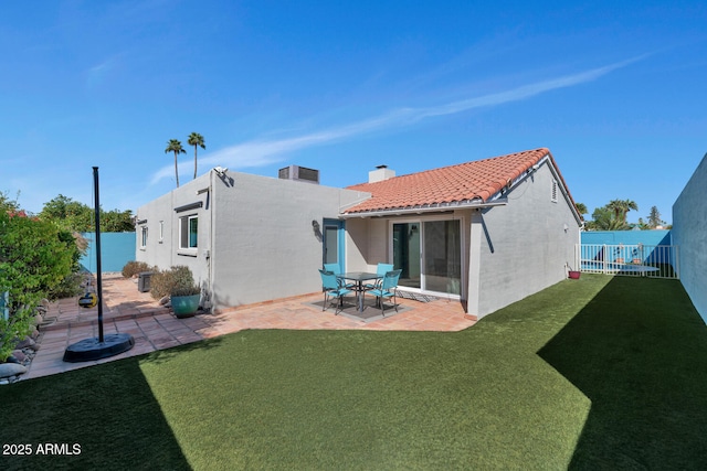 rear view of house with a tile roof, a patio area, a fenced backyard, and stucco siding