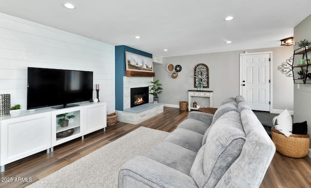 living area featuring a fireplace, baseboards, wood finished floors, and recessed lighting