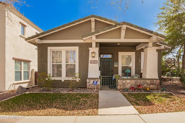 entrance to property with covered porch and stucco siding