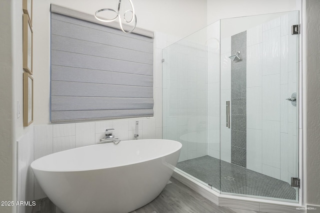 28437 N 112th Way, Scottsdale, AZ 85262 - bathroom with wood finished floors, a chandelier, a shower stall, tile walls, and a soaking tub