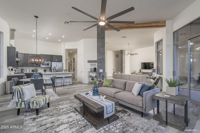 28437 N 112th Way, Scottsdale, AZ 85262 - living area with a high ceiling, beam ceiling, light wood-style floors, visible vents, and ceiling fan with notable chandelier