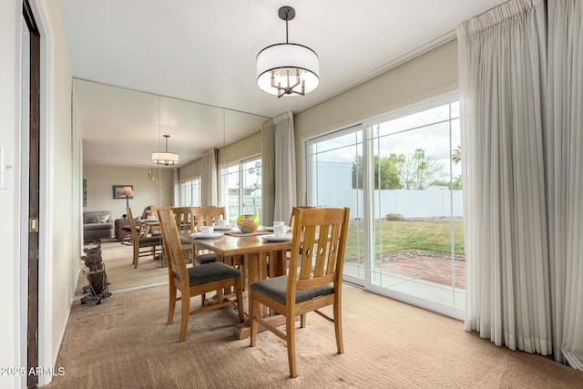 dining room with a chandelier and light colored carpet