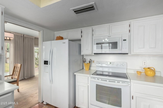 kitchen featuring visible vents, white appliances, white cabinets, and light countertops