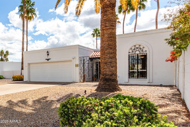 view of front of home featuring concrete driveway, an attached garage, fence, and stucco siding