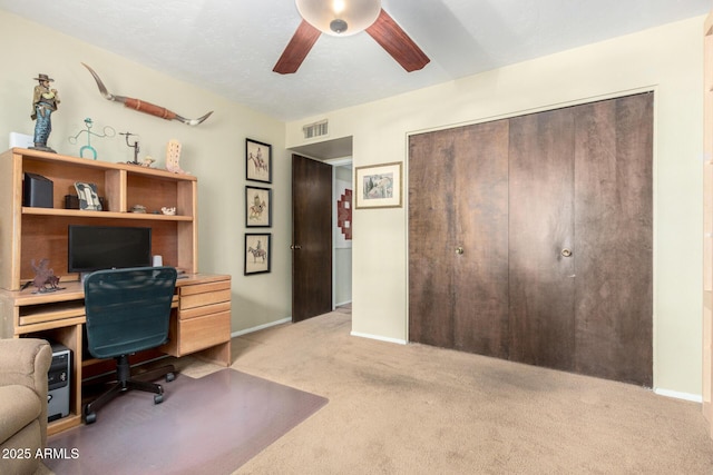 office with visible vents, baseboards, light colored carpet, and ceiling fan