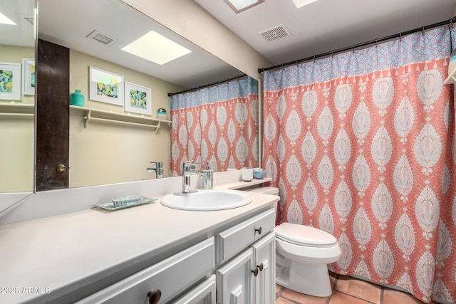 bathroom with tile patterned flooring, toilet, vanity, and visible vents