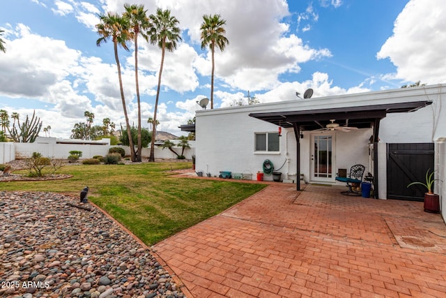 rear view of house featuring a lawn, a ceiling fan, a patio, and fence