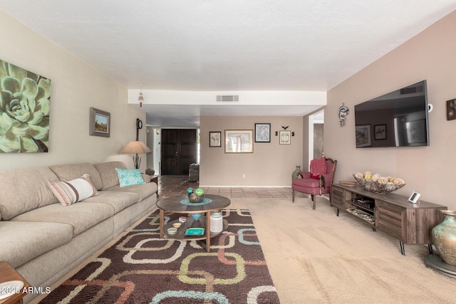 carpeted living area featuring visible vents and baseboards