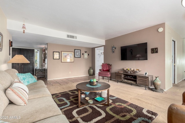 living area featuring visible vents, baseboards, and carpet