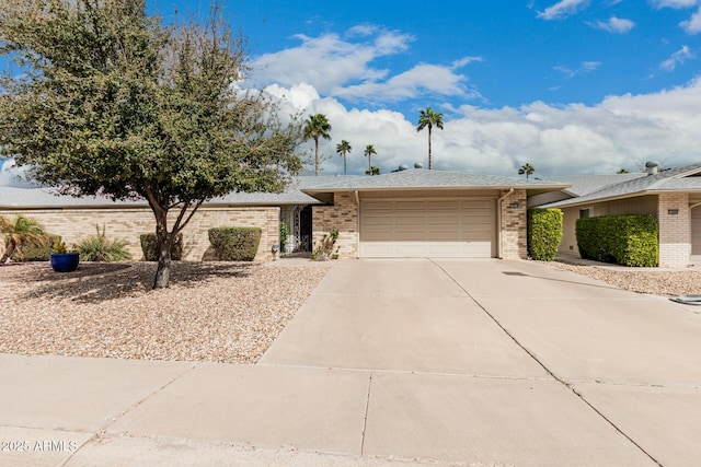 view of front facade featuring an attached garage, concrete driveway, and brick siding