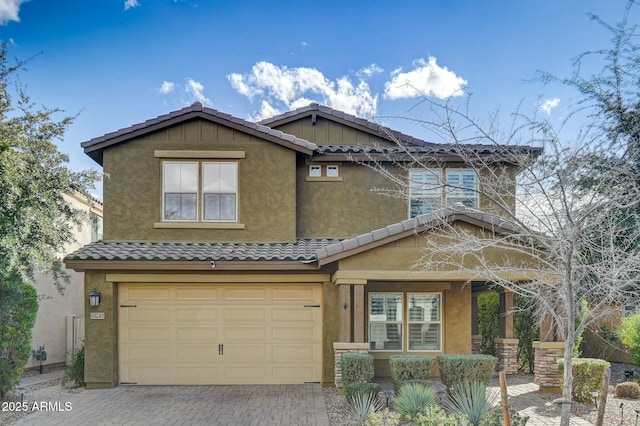 view of front of property featuring decorative driveway, a tile roof, and stucco siding