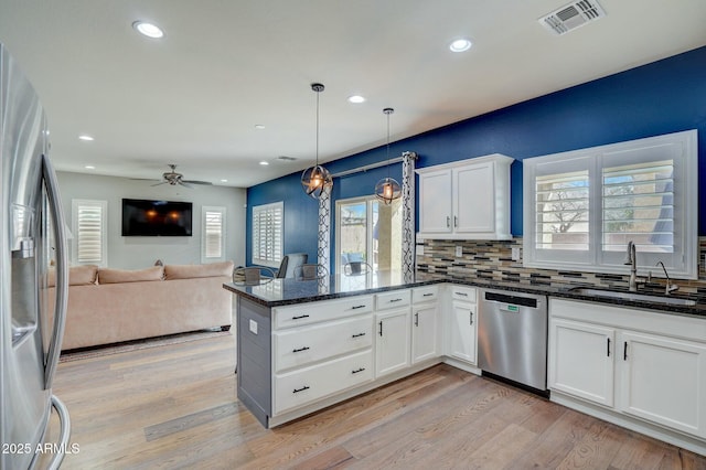 10249 E Kinetic Dr, Mesa, AZ 85212 - kitchen with appliances with stainless steel finishes, a peninsula, a sink, white cabinets, and light wood-type flooring