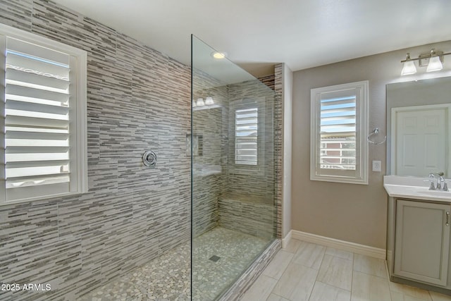10249 E Kinetic Dr, Mesa, AZ 85212 - bathroom featuring a walk in shower, baseboards, and vanity