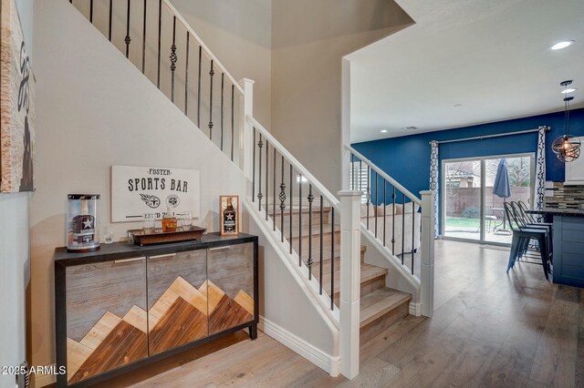 10249 E Kinetic Dr, Mesa, AZ 85212 - stairs featuring wood finished floors, a dry bar, baseboards, and recessed lighting