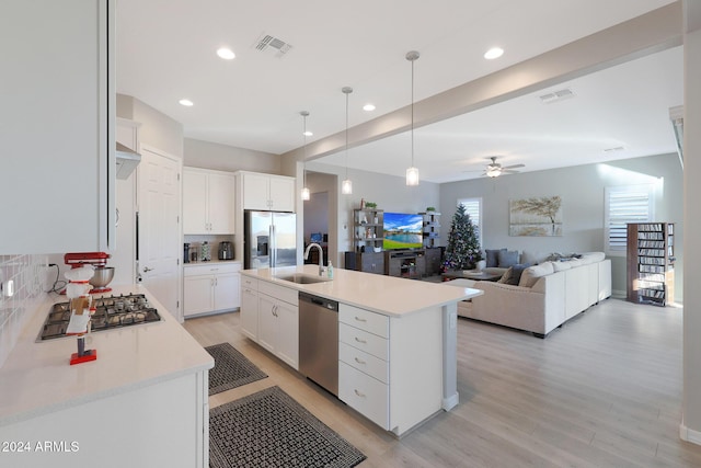 kitchen featuring visible vents, a sink, light wood-style flooring, and appliances with stainless steel finishes