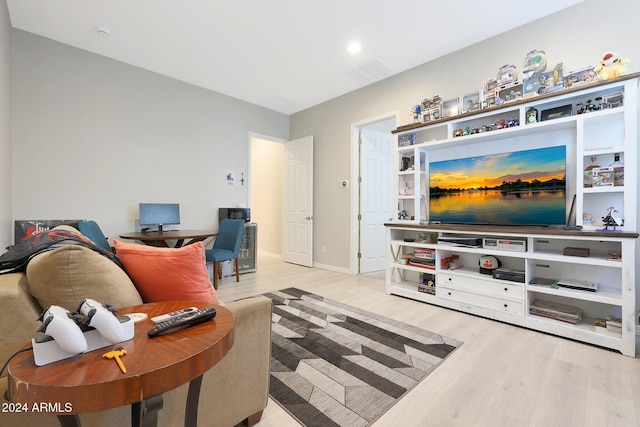living room with light wood-type flooring, baseboards, and visible vents