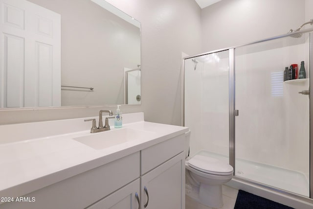 bathroom featuring vanity, toilet, and a stall shower