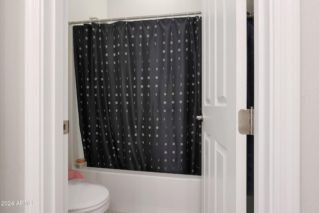 bathroom with shower / bath combo and toilet