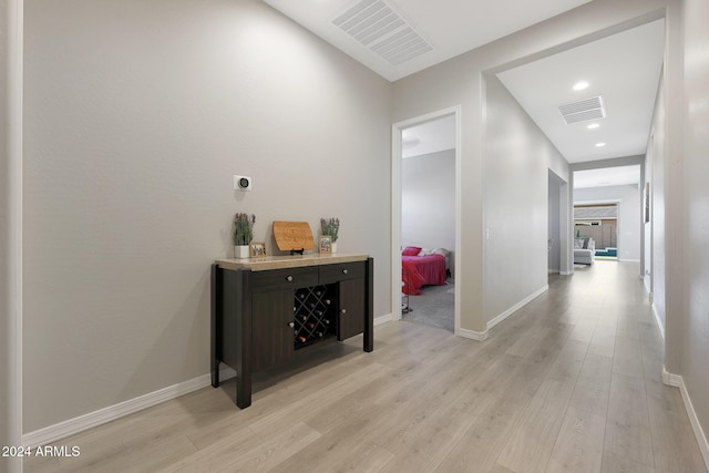 hallway featuring visible vents, recessed lighting, light wood-style floors, and baseboards