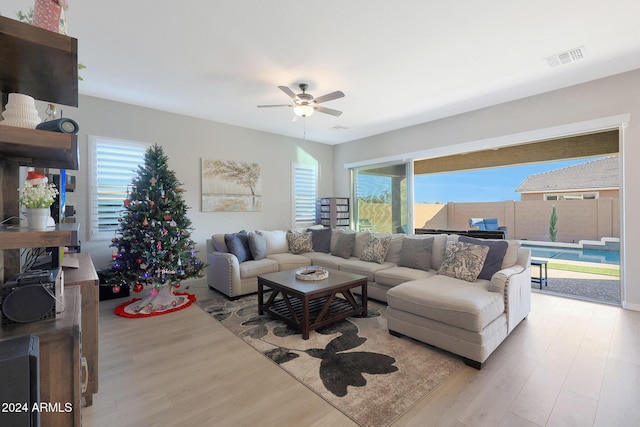 living area with ceiling fan, visible vents, and wood finished floors